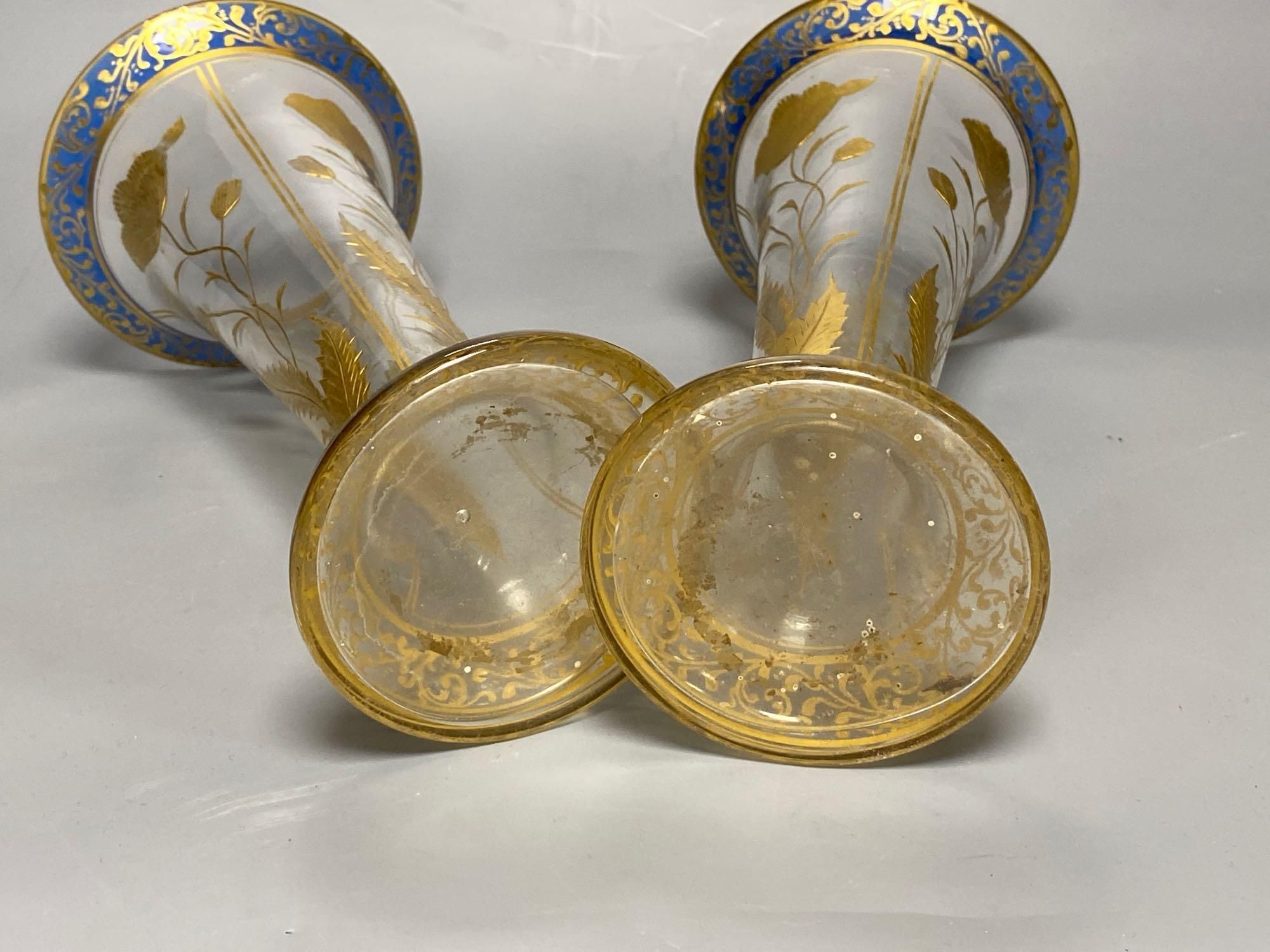 A pair of Bohemian gilt painted and blue flash cut trumpet shaped glass vases, 26cm